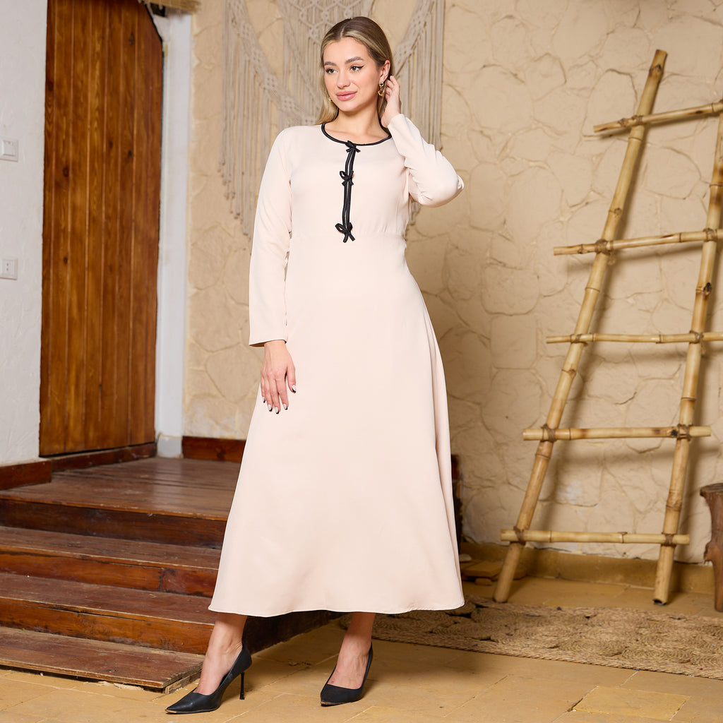 Elegant Beige Long-Sleeved Dress with Black Trim and Decorative Knots