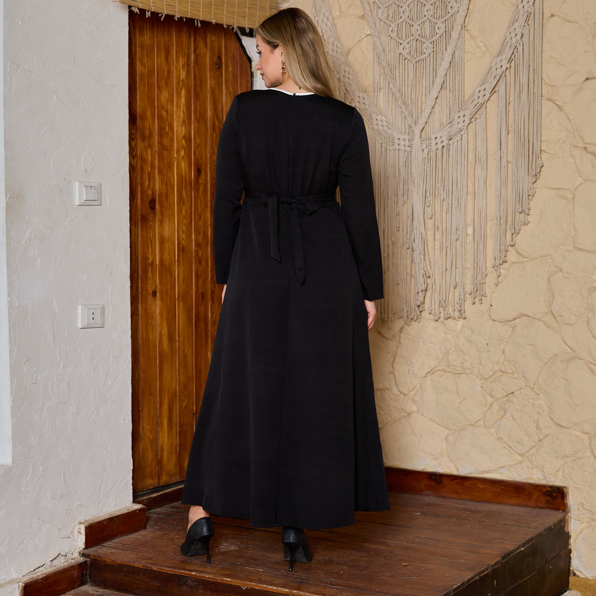 Elegant Black Long-Sleeved Dress with White Trim and Decorative Knots